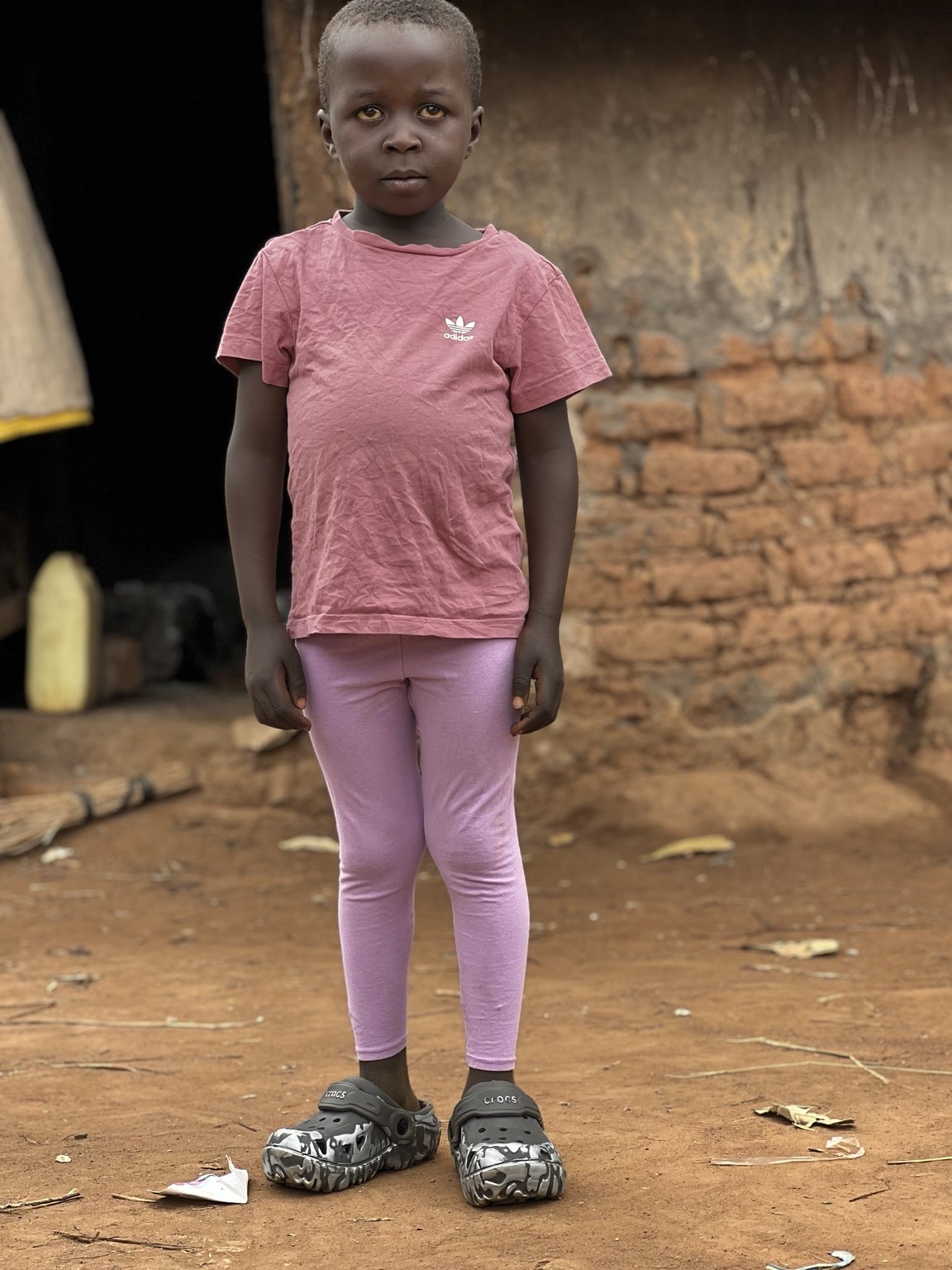 Child standing outside a rural home